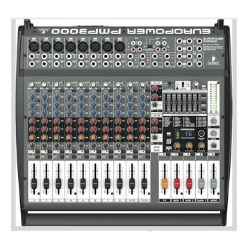 Šedý mixážní pult s černými ovládacími prvky. V horní části je nápis EUROPOWER PMP3000 a logo BEHRINGER. Zařízení obsahuje několik vstupních kanálů s…