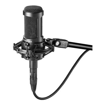 Černý kondenzátorový mikrofon umístěný v odpruženém držáku na černém stativu. Na těle mikrofonu je bílý nápis audio-technica. Na spojovací části stat…