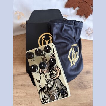 Kremově bílý kytarový efekt s černými ovládacími knoflíky a nápisy vol, 3v, gain, bass, mode, treb. Na spodní části je nápis EONS a logo Walrus Audio…