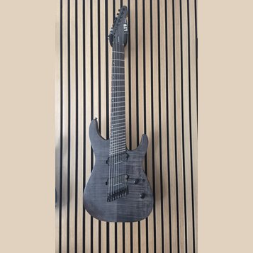 Šedá elektrická kytara s tmavým hnedým povrchem a viditelnou strukturou dřeva. Na hlavě je bílý nápis LTD Deluxe. Nástroj má dva humbuckery, jeden ov…