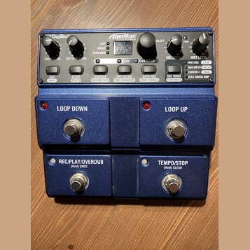 Modrý loop pedál značky Digitech s názvem JamMan STEREO. Zařízení má čtyři stoupací spínače s nápisy LOOP DOWN, LOOP UP, REC/PLAY/OVERDUB (Hold) UNDO…