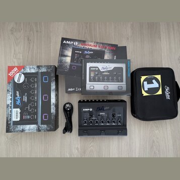 Sada obsahuje kytarový zesilovač v černé barvě s nápisy AMP 1 a BluGuitar, krabici, manuály v češtině a angličtině, napájecí kabel a černý přepravní…