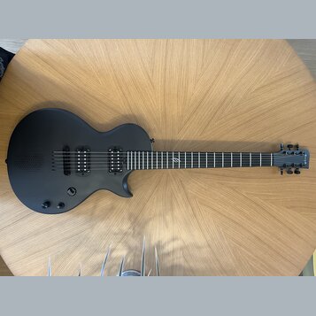 Černá elektrická kytara s matným povrchem a dvěma humbuckery. Na hlavě hředu je bílý nápis "Yamaha". Hриф obsahuje jeden viditelný znak vtíraný do hm…