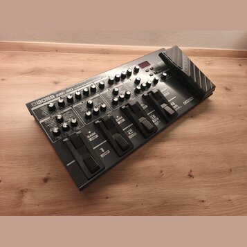 Šedý multifunkční kytarový procesor s výrazným nápisem BOSS ME-80 Guitar Multiple Effects. Zařízení obsahuje řadu otočných knoflíků, přepínačů a pět…