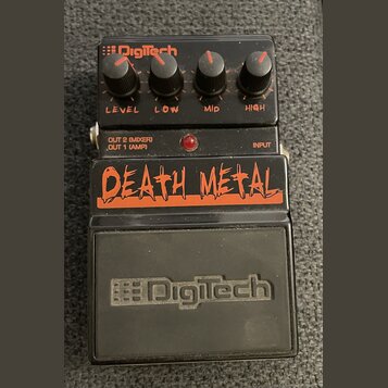 Černý kytarový efekt s nápisem DEATH METAL™ v oranžové barvě. Na horní části je logo DigiTech a čtyři ovládací knoflíky s popisky LEVEL, LOW, MID a H…