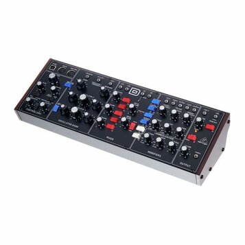 Černý modulární syntetizátor v dřevěném šasi s bílým spodním panelem. Na horním panelu jsou rozděleny sekce s názvy CONTROLLERS, OSCILLATOR BANK, MIX…