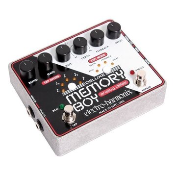 Bílý efekt pedál s červeným okrajem a kovovým šasi. Na horní straně je nápis DELUXE MEMORY BOY analog delay electro-harmonix a text MADE IN NYC, USA.…