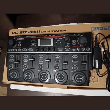 Černá loop station značky BOSS s nápisem RC-505mkII LOOP STATION. Zařízení má pět ovládacích sekcí s velkými kulatými tlačítky, posuvníky a různými o…