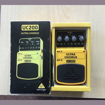 Fotografie zobrazuje žlutý kytarový efekt UC200 ULTRA CHORUS značky behringer v originální krabici. Na pedálu jsou čtyři ovládací knoflíky s popisky…