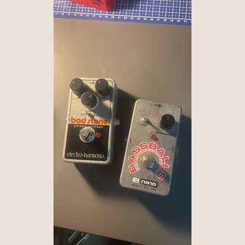 Dvě efektové pedály s kovovým stříbrným povrchem. Levý pedal má nápisy bad stone, phase shifter a electro-harmonix, dva černé knoflíky a přepínač AUT…