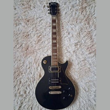 Černá elektrická kytara s tvarem single-cutaway a hnědým hmatníkem. Na hlavě je bílý nápis Lizmaud. Kytara má dva humbuckery, čtyři ovládací knoflíky…