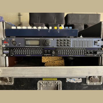 V hliníkovém rackovém kufru jsou namontovány dvě zařízení. Horní přístroj má logo dbx PROFESSIONAL PRODUCTS a nápis DriveRack, obsahuje displej a ovl…