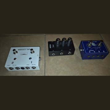 Tři kytarové pedály v různých barvách. Bílý pedal má nápisy WIDARA, DUAL LOOPER a TRUE BYPASS BOX, dvě stoupací spínače a čtyři konektory s označením…