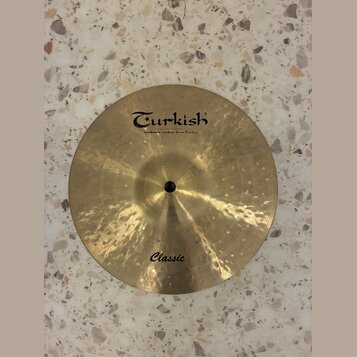 Kruhové činely z mosazného kovu s kovaným povrchem. Na horní části je černý nápis Turkish a pod ním menší text handmade cymbals from Turkey. Ve spodn…