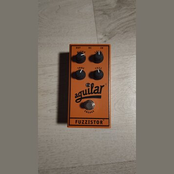 Oranžový kytarový efekt pedál s nápisy BLEND, LEVEL, TONE a FUZZ u ovládacích knoflíků. Uprostřed je černé logo aguilar a v dolní části nápis FUZZIST…