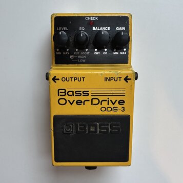 Žlutý kytarový pedál s nápisem Bass OverDrive ODB-3 a logem BOSS na spodním černém spínacím tlačítku. Horní panel obsahuje čtyři ovládací knoflíky s…
