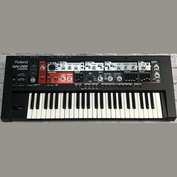 Černý syntetizátor s bílými a černými klávesami. Na levé straně je bílý nápis Roland SH-201 SYNTHESIZER. Horní panel obsahuje množství ovládacích prv…