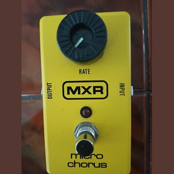 Žlutý efektový pedál s nápisem MXR v černém rámečku. V horní části je text micro chorus a v dolní části ovládací knob s popiskem RATE. Na bocích jsou…