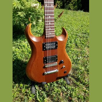Elektrická kytara s hnědým dřevěným povrchem a dvěma humbuckery. Na spodním snímači je viditelný nápis "Seymour Duncan". Kytara má jeden ovládací kno…