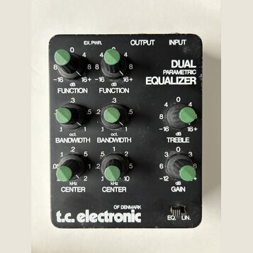 Černý kytarový efekt s nápisem DUAL PARAMETRIC EQUALIZER a logem t.c. electronic OF DENMARK. Zařízení má šest zelených otočných knoflíků s popisy FUN…