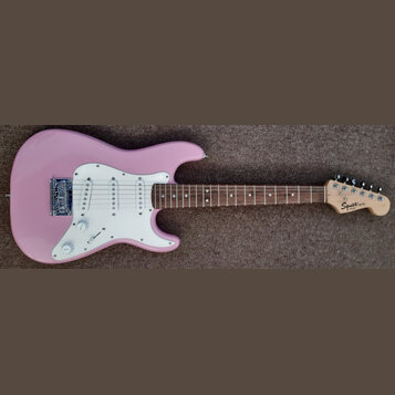 Růžová elektrická kytara s bílým pickguardem a hnědým hmatníkem. Na hlavě kytary je nápis Squier MINI by Fender. Nástroj vykazuje v dobrém stavu povr…