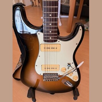 Elektrická kytara s tónem těla v hnědém sunburst provedení a bílým pickguardem. Nástroj má dva snímače typu humbucker a třicetiletý hnedý hmatník. Na…