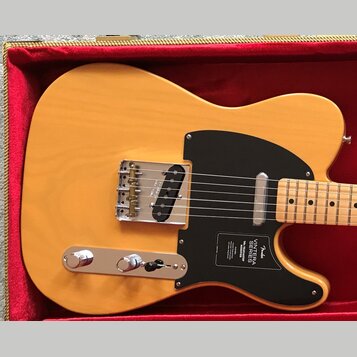 Elektrická kytara s přírodním žlutým povrchem těla a černým pickguardem, umístěná v červeném kufru. Na pickguardu je bílý nápis Fender VINTERA SERIES…