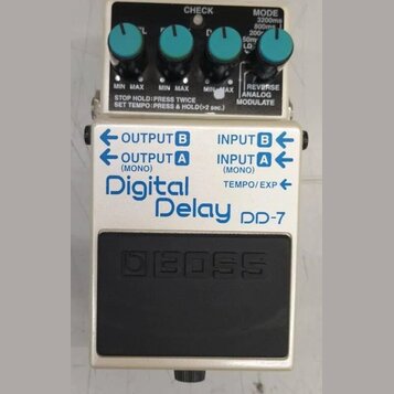 Kytarový efekt pedál značky BOSS, model Digital Delay DP-7. Zařízení má bílé tělo s modrými nápisy a čtyři tyrkysové ovrtovací knoflíky. Na horním če…