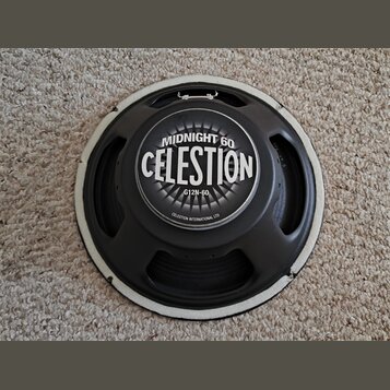 Černý reproduktor s bílým těsněním po obvodu. Uprostřed je štítok s nápisy MIDNIGHT 60, CELESTION a G12N-60, v dolní části je drobným písmem uvedeno…