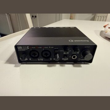 Černý audio rozhraní s nápisem UR22C AUDIO INTERFACE 32-bit/192Hz a logem steinberg. Na přední straně jsou dva kombinované vstupy D-PRE MIC/LINE, ovl…