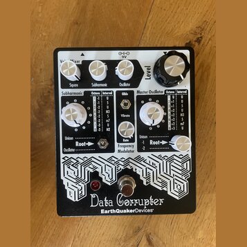 Bílý efekt pedál s černým nápisem Data Corrupter a logem EarthQuakerDevices. Zařízení má několik bílých otočných knoflíků s popisky Voice Mixer (Squa…