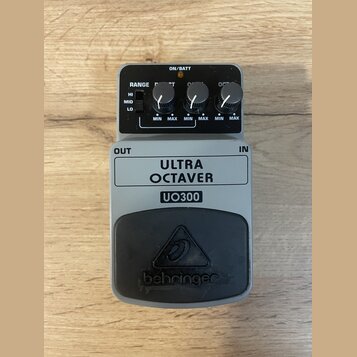 Šedý kytarový efekt s černým gumovým pedálem. Na šedém těle je nápis ULTRA OCTAVER UO300 a na gumové části logo behringer. Ovládací panel obsahuje př…