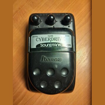 Černý kytarový efekt pedál s nápisem CYBERDRIVE a SOUNDTANK CD5. Na spodní části je vyrazeno logo Ibanez. Pedál má tři ovládací knoflíky s popisky LE…