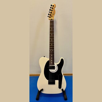 Bílá elektrická kytara s černým pickguardem a hnědým hmatníkem. Na hlavě je viditelné logo Fender a na pickguardu nápis Fender Mono-caster. Nástroj j…