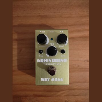 Kytarový efekt pedál v olivově zelené barvě s kovovým šasi. Na povrchu jsou nápisy WAY HUGE, GREEN RHINO a OVERDRIVE MKV. Zařízení má tři hlavní otoč…
