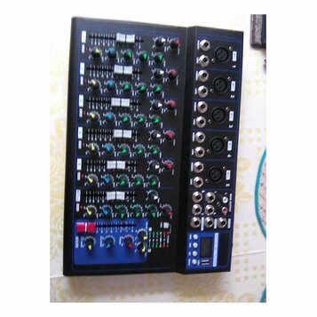 Černý mixážní pult s modrým rámem. Na pravé straně jsou vstupní konektory XLR a jack, v dolní části je digitální displej. Ovládací panel obsahuje pos…
