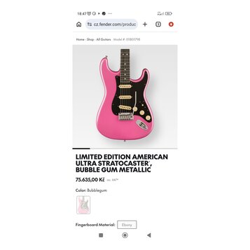 Snímek zachycuje růžovou elektrickou kytaru typu Stratocaster s černým pickguardem a zlatými prvky. Pod nástrojem je text LIMITED EDITION AMERICAN UL…