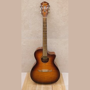 Akustická kytara s vyřezem v těle, provedená v hnědém sunburst odstínu. Na hlavě je bílý nápis Fender a na hradle je vidět nápis CALABRE S. Povrch ná…