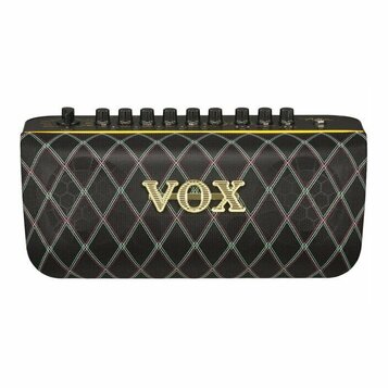 Černý kytarový kombo zesilovač s látkovou mřížkou v kosočtvercovém vzoru. Uprostřed je umístěno zlaté logo VOX. Horní ovládací panel obsahuje řadu če…