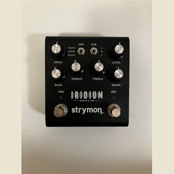 Černý kytarový pedál s nápisy IRIDIUM, amp & ir cab a značkou strymon. Na horní straně jsou čtyři ovládací knoflíky s popisky DRIVE, MIDDLE, TREBLE a…