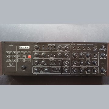 Černý analogový polyfonní syntetizátor s nápisem Pro-800 a logem behringer. Přední panel obsahuje početné otočné knoflíky, posuvníky a tlačítka pro o…