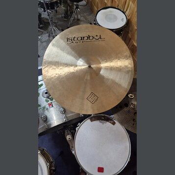 Zlatavý kovový činel s viditelným broušením a hámrnutím povrchu. Na povrchu je černý nápis istanbul Agop Handmade cymbals from Turkey a v dolní části…