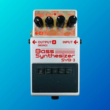 Stříbrný kytarový pedál s nápisem Bass Synthesizer SYB-3. Na horní straně jsou čtyři černé ovládací knoflíky a červená kontrolka CHECK. V dolní části…