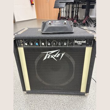 Kytarový kombo zesilovač značky Peavey s modelem Special 130. Má černý kryt, bílou mřížku reproduktoru a ovládací panel s několika potenciometry a př…