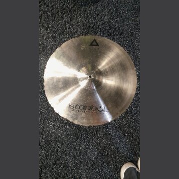 Kruhové činely z kovu s broušeným povrchem a nepravidelným okrajem. Na spodní části je černý nápis istanbul Agop Made in Turkey. V horní části je vid…