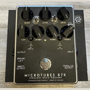 Černý kytarový pedál s kovovým rámem a nápisem MICROTUBES B7K ANALOG BASS PREAMP DARKGLASS ELECTRONICS - MADE IN FINLAND. Zařízení má osm ovládacích…