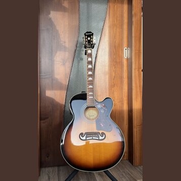 Akustická kytara s vyřezem (cutaway) v provedení sunburst. Na hlavě je nápis Epiphone a na hradle se nachází štítek s textem GUARANTEED Lifetime Warr…
