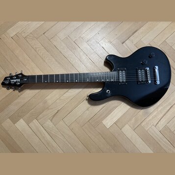 Černá elektrická kytara s dvojstupňovými humbuckery a fixním mostem. Na hlavě je bílý nápis Washburne a označení modelu BF-2. Nástroj vykazuje mírné…