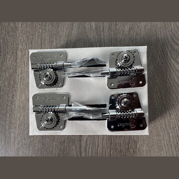 Dvě sady chromovaných ladících mechanismů v bílém kartónovém obalu. Každý mechanismus má na kovové základně vyražený nápis Fender. Součástí jsou ladi…