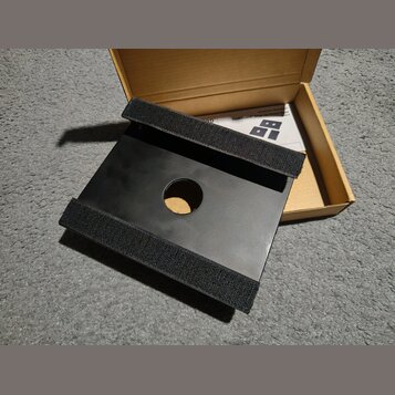 Černý obdélníkový podložkový systém s kulatým otvorem uprostřed. Na kratších stranách jsou připevněny široké pásy černého suchého zipu. Příslušenství…